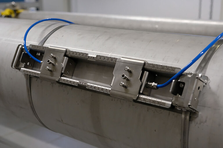 Abbildung einer geöffneten Clamp-On Sensor-Schiene, angebracht auf einem Rohr